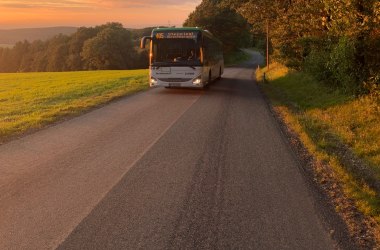 Linienbus unterwegs in Herbstlandschaft